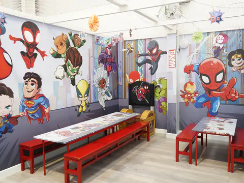 Superhero themed private party room with tables prepared and no guests present.